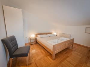 sypialnia z łóżkiem i krzesłem w obiekcie Apartman Elizabeth w Krku