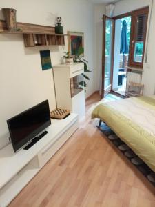 een slaapkamer met een bed en een bureau met een televisie bij Apartment Veronika in Vandoies