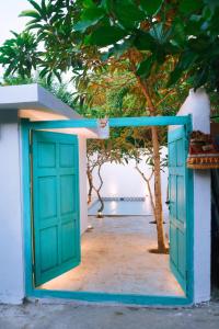 a blue door on a white building with a tree at PROMO! 2BRV With premium Pool in Uluwatu