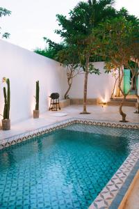 a swimming pool in the middle of a yard with trees at PROMO! 2BRV With premium Pool in Uluwatu