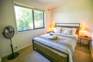 a bedroom with a bed with a window and a fan at Abbeville In Bright in Bright