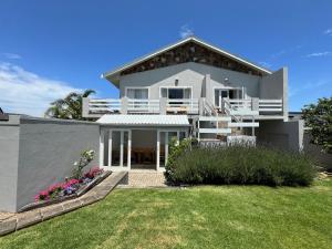 a large white house with a yard at Moments Guesthouse, Kleinmond in Kleinmond