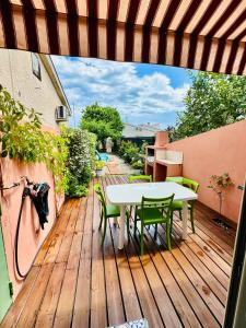 una terrazza in legno con tavolo, sedie e ombrellone di Casa Marana a Borgo