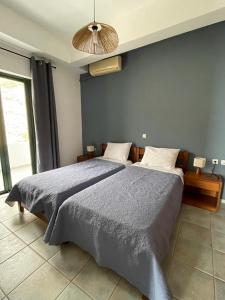 a bedroom with two beds and a large window at 4Seasons Sfakia in Khóra Sfakíon