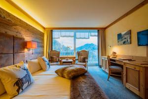 um quarto de hotel com uma cama, uma secretária e uma janela em revita - naturresort & spa em Bad Lauterberg