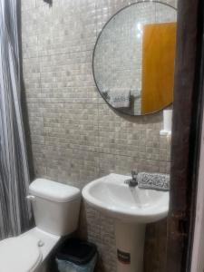 uma casa de banho com um lavatório, um WC e um espelho. em La casa de naty by Ecuapolsky em Tonsupa
