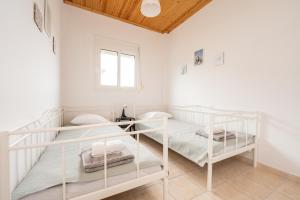 two bunk beds in a white room with a window at Flegra House in Nea Potidaea