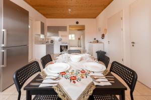 a dining room table with chairs and a kitchen at Flegra House in Nea Potidaea