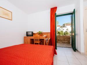 a bedroom with a bed and a table with a television at Holiday resort Zaton Holiday Resort Zaton-Nin - CDN02044-CYB in Zaton