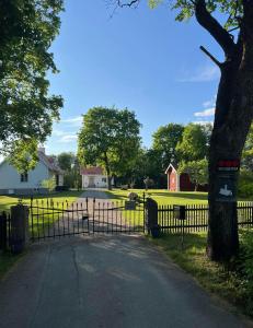 una puerta a una entrada con una casa y un árbol en Prästgården en Norberg