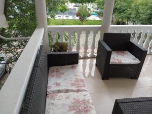 瓦利波約的住宿－Titi's home Velipoje，阳台配有两把椅子和门廊上的地毯