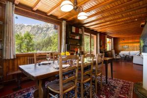 Un comedor con una mesa y un gran ventanal. en MontBlanc Alpine Ski & Sauna Retreat - Happy Rentals, en Le Tour