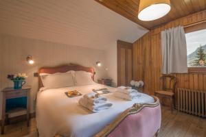Un dormitorio con una cama con toallas. en MontBlanc Alpine Ski & Sauna Retreat - Happy Rentals, en Le Tour