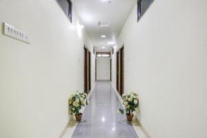 um corredor de um edifício com dois vasos de plantas em FabHotel Naresh Palace em Raipur