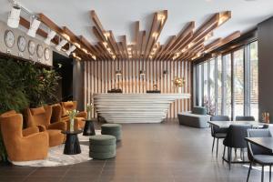 un vestíbulo con una zona de espera con sillas y mesas en Kennigo Hotel Brisbane, Independent Collection by EVT, en Brisbane
