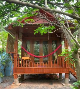 una casa en el árbol con una cinta roja alrededor en Retro Kampot Guesthouse en Kampot