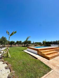 a swimming pool in a field with a palm tree at Villa Santo Stefano in Monopoli