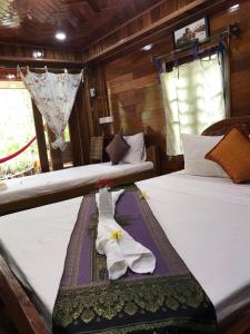 two beds in a room with towels on them at Retro Kampot Guesthouse in Kampot