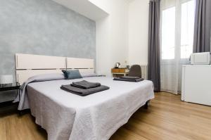 een slaapkamer met een wit bed met twee handdoeken erop bij Blue Room in Milaan