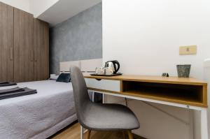 een slaapkamer met een bed en een bureau met een stoel bij Blue Room in Milaan