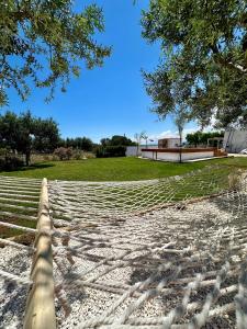 a hammock on a beach with a house in the background at Villa Santo Stefano in Monopoli