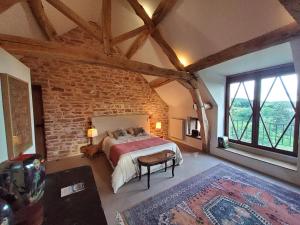 Un dormitorio con una cama y una pared de ladrillo. en La Parenthèse à Etrigny, en Étrigny