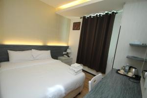 Cukai的住宿－世紀酒店，卧室配有白色的床和窗户。