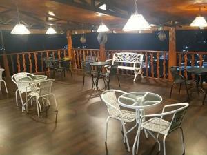 a group of tables and chairs in a restaurant at RedDoorz at Hotel Ermashta Jayapura in Jayapura