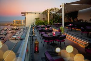 un restaurante con mesas y sillas en un balcón en Mysk Al Mouj Hotel en Mascate