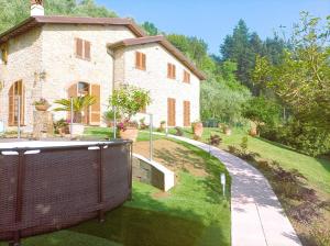 una casa con una recinzione di fronte a un cortile di Villa Camelia Tuscany a Pescia
