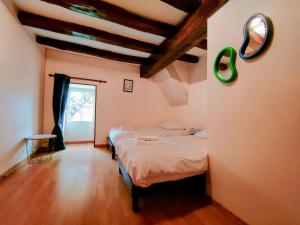 a bedroom with two beds and a mirror on the wall at La Petite Fontaine- Séjour à Migé in Migé