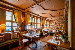 un ristorante con soffitti e tavoli in legno e sedie di revita - naturresort & spa a Bad Lauterberg