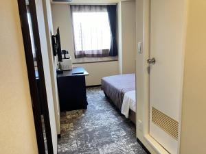 Postel nebo postele na pokoji v ubytování HOTEL LiVEMAX BUDGET Shinosaka