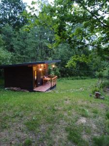 a small black cabin in the middle of a field at Gradina Tisa in Comăneşti