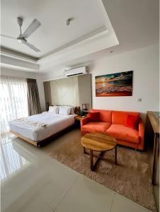 Habitación de hotel con cama y sofá rojo en Negombo Ocean View Luxury Studio by Serendib Vacation, en Negombo