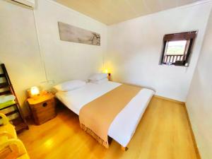 a bedroom with a white bed and a window at Tulou Fuyulou Changdi Inn in Yongding