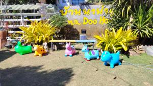 un groupe de chiens jouets debout autour d'un banc dans l'établissement Na Na Doo Homestay, à Chiang Rai