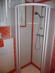 y baño con ducha y azulejos rojos. en Red Apartment, en Bratislava
