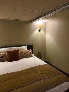 een slaapkamer met een bed met een lamp aan de muur bij City Stay&Go Enschede in Enschede