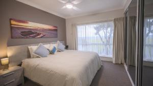 a bedroom with a white bed and a large window at Apartment 5 - The Meridian in Old Bar
