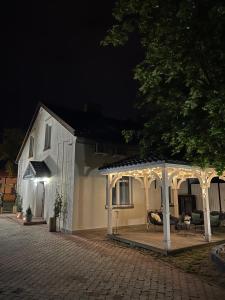 a white gazebo in front of a house at night at Apartamenty - Dom Hrabiny in Sieradz