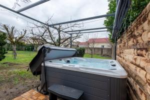 a hot tub in a backyard with a pergola at Belle maison rénovée avec jacuzzi in Saint-Rémy