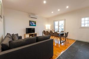 a living room with a couch and a dining room at Belle maison rénovée avec jacuzzi in Saint-Rémy
