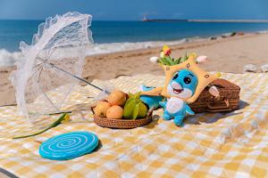 eine Picknickdecke mit Obst und einem ausgestopften Tier und einem Regenschirm in der Unterkunft Crowne Plaza Resort Sanya Bay, an IHG Hotel in Sanya