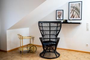 a black rocking chair in a room with a staircase at Boutique Apartment Niederrhein in Friedrichsfeld