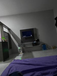 a bedroom with a bed and a tv on the wall at Adesha Guest House in Tondo