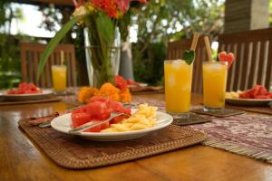 una mesa de madera con una bandeja de fruta y aperitivos en Villa Sha San Gar, en Banjar