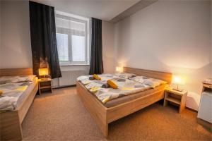 two beds in a room with two lamps and a window at Hotel & SPA centrum PALMIRA in Uherský Brod