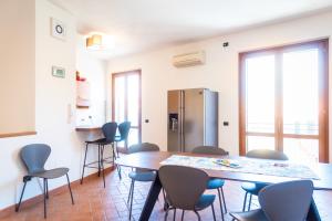 Cette chambre dispose d'une table, de chaises et d'un réfrigérateur. dans l'établissement Appartamento Barlumi, à Marciana Marina