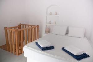 a white bed with two towels on top of it at Thavma Milos in Firopótamos